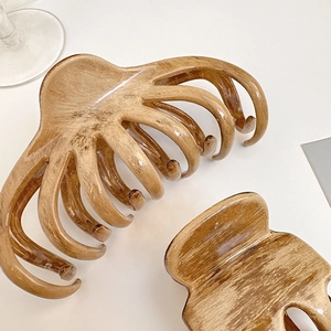 Detailed view of two large amber marble hair claws with octopus-style grip teeth