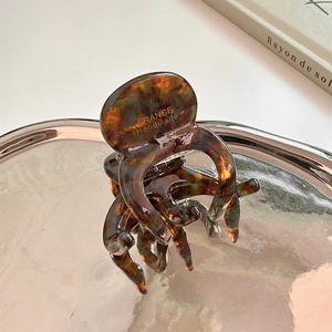 Détail d'une pince à cheveux en acétate écaille avec logo France Handmade doré gravé