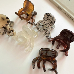 Vue détaillée de six petites pinces à cheveux poulpe en acétate aux motifs marbrés et écaille