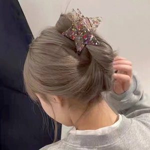 Detailed view of pentagram star hair claw clip with colorful sequins in a chic bun hairstyle