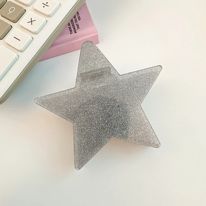 Macro detail of silver star-shaped hair claw clip with sparkly glitter finish