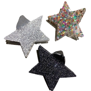 Three stylish star-shaped hair clips in silver, transparent, and dark glitter finishes
