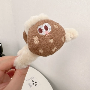 Dettaglio ravvicinato della molletta per capelli in peluche con ricami e consistenza morbida
