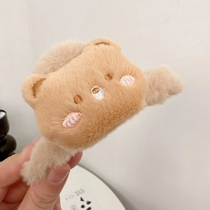 Dettaglio del fermaglio per capelli in peluche orsetto marrone con ricami e morbida finitura