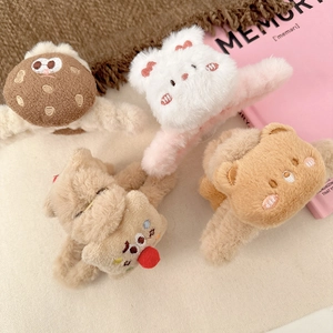 Dettaglio di quattro mollette per capelli in peluche con texture morbida e orsetti