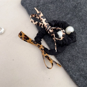 Detailed view of leopard print bow hair ties with elegant white pearls and elastic bands