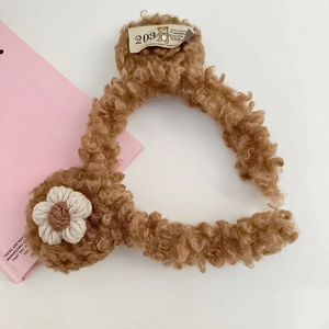 Detail of plush brown teddy fleece headband with knitted flower and vintage cloth label
