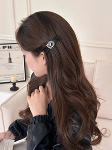 Detail of elegant black hair comb with sparkling square rhinestones worn on hair