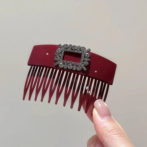Detail of elegant wine red acrylic hair comb with sparkling square rhinestone buckle