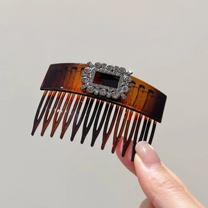 Detail view of brown tortoiseshell hair comb with a sparkling rectangular rhinestone buckle