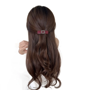 Elegant burgundy hair comb with square rhinestones worn on long wavy brown hair