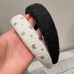 Gros plan sur des serre-têtes épais en tweed avec paillettes florales noires et blanches