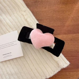 Pince à cheveux élégante en velours noir avec cœur en peluche rose sur fond esthétique