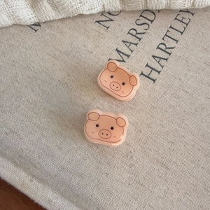 Set di due mini fermagli per capelli a forma di maialino rosa in resina su beige