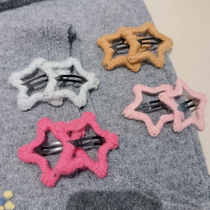 Vue détaillée de barrettes tricotées en forme d'étoile en blanc, kaki, rose et rouge