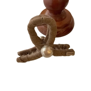 Elegant brown knit texture hair claw clip with large pearl accent and Lovedays label