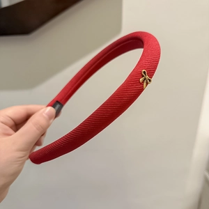Elegant red knitted headband with a small gold butterfly detail for a high-volume look