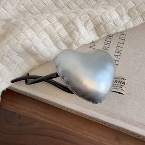 Elegant silver heart-shaped hair claw clip with metallic padded texture and black base
