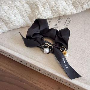 Elegant black satin hair scrunchie with camellia flower and pearl charms on ribbon