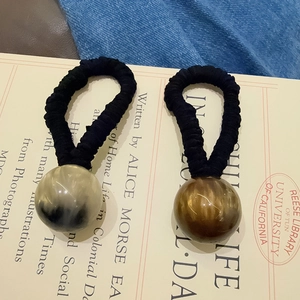 Close-up of elastic hair ties with marble pattern beads and pleated fabric texture