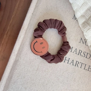 Vintage brown scrunchie with metallic smiley face pendant and pleated fabric design