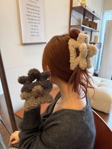 Mollette per capelli in peluche a forma di stella in beige, grigio scuro e caffè sul modello
