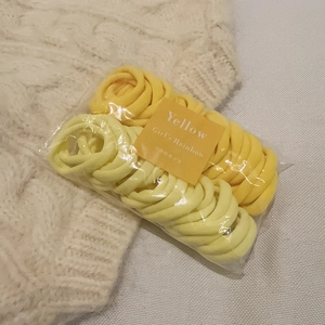 Elastici per capelli senza cuciture dai colori caramella su un maglione di maglia