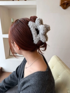 Dettaglio della molletta a stella in peluche grigio per acconciature invernali