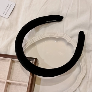 Detail shot of a black velvet polka dot headband on a white ceramic plate