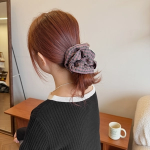 Pink and green plaid oversized scrunchie hair tie on model for elegant bun hairstyle