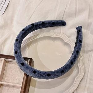 French vintage wide denim headband with black flocked polka dots on a white ceramic plate