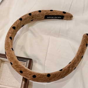 Retro brown padded headband with black polka dots and handmade label on white fabric