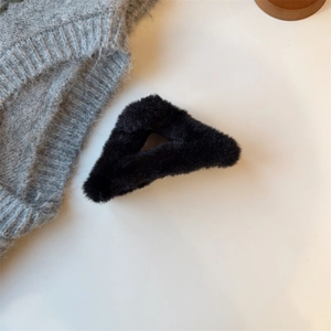 Detail einer flauschigen schwarzen hohlen Dreieck-Haarklammer mit Kunstfell-Textur