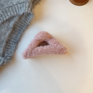 Detailaufnahme einer rosa Plüsch Haarklammer in Dreieckform mit weicher Pelzoptik