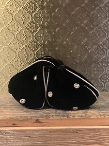 Macro detail of black velvet hair claw with rhinestones and elegant white trim finish