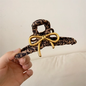 Elegant leopard print fabric claw clip with gold metal bow accent for women