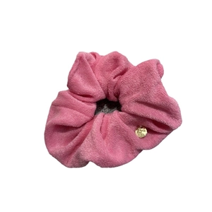 Pink towel fabric scrunchie with elegant golden metal pendant on white background