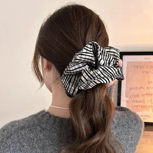 Minimalist black and white striped fabric scrunchie on a stylish brunette ponytail