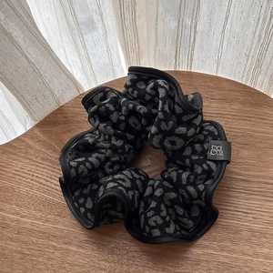 Close-up of leopard print hair tie with soft fabric texture and black woven edges