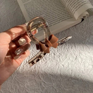 Brown bow hair claw clip made of acrylic with transparent resin design for women