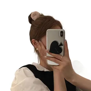 Elegant beige fabric rose hair scrunchie with faux pearl on a low bun hairstyle