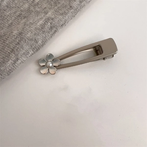 Détail de la pince à cheveux en alliage doré champagne avec motif fleur de perle