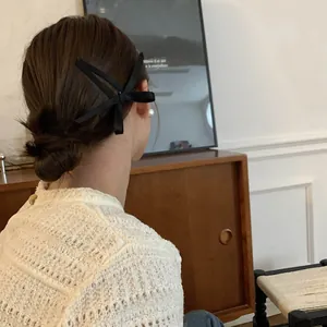 Elegante fermaglio per capelli in nastro di seta nera indossato sul lato dell'acconciatura