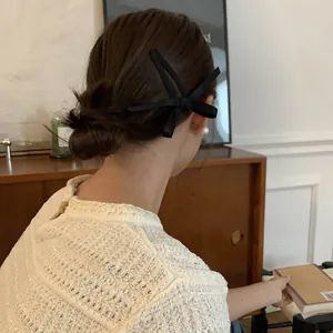 Dettaglio di un elegante fermaglio per capelli con fiocco nero per uno stile minimal