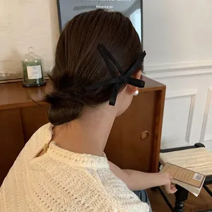 Elegante fermaglio per capelli in nastro di seta nero con lunghi nastri su uno chignon