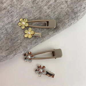 Détail de quatre pinces à cheveux florales en métal avec perles en doré et argenté