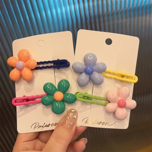 Set of four colorful flower hair clips in orange, purple, green and pink for girls