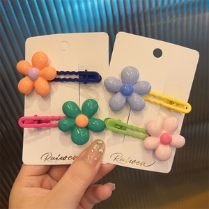 Close-up of candy-colored flower hair clips with pastel resin petals and metal wavy base