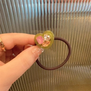 Close-up of olive green heart hair tie with pink and orange crystal rhinestones