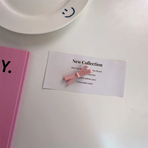 Dettaglio macro di un fermaglio per capelli a fiocco rosa opaco su sfondo minimalista